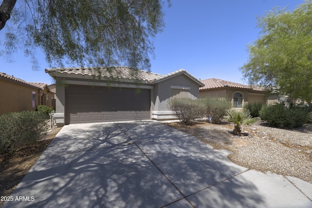 41388 W Hopper Dr, Maricopa, AZ 85138 - view of front of home with an attached garage, driveway, stucco siding, and a tile roof