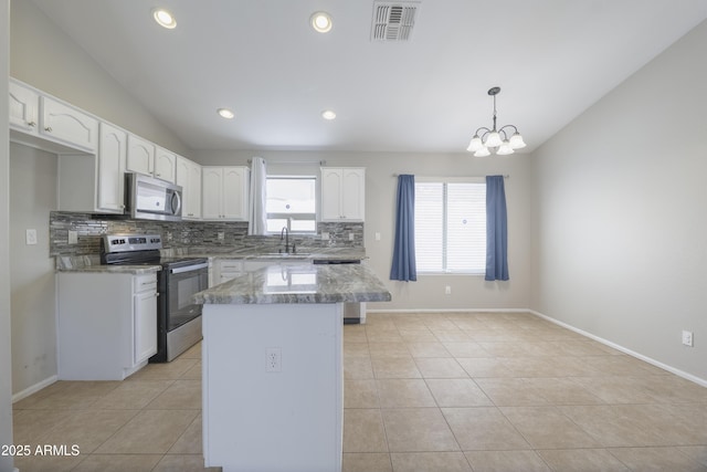 41388 W Hopper Dr, Maricopa, AZ 85138 - kitchen with stainless steel appliances, tasteful backsplash, white cabinetry, light tile patterned flooring, and a center island