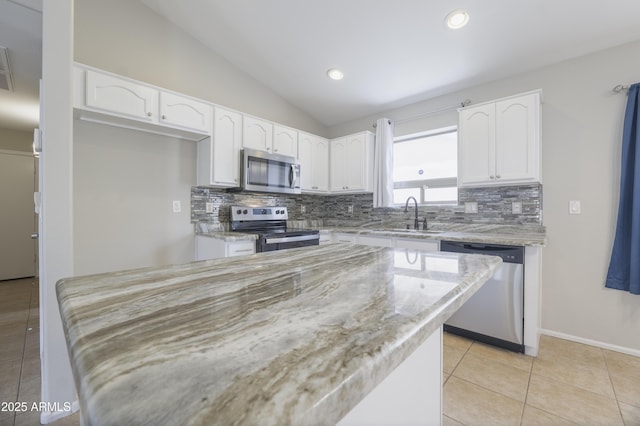 41388 W Hopper Dr, Maricopa, AZ 85138 - kitchen featuring stainless steel appliances, tasteful backsplash, white cabinetry, lofted ceiling, and light stone countertops