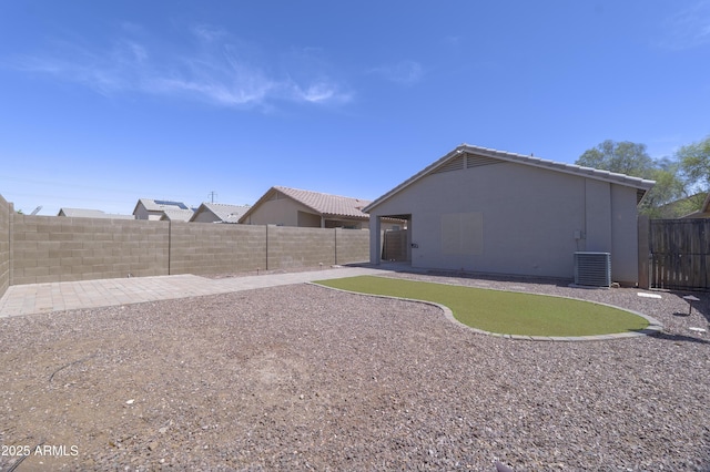 41388 W Hopper Dr, Maricopa, AZ 85138 - fenced backyard featuring cooling unit, a patio, and a putting area