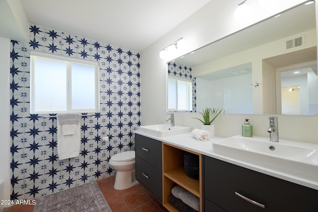 bathroom with toilet, vanity, and tile patterned floors