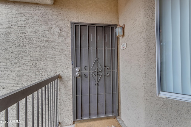 doorway to property featuring stucco siding