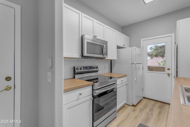 2929 W Yorkshire Dr Unit 2013, Phoenix, AZ 85027 - kitchen featuring stainless steel appliances, light wood-style flooring, white cabinetry, a sink, and wood counters