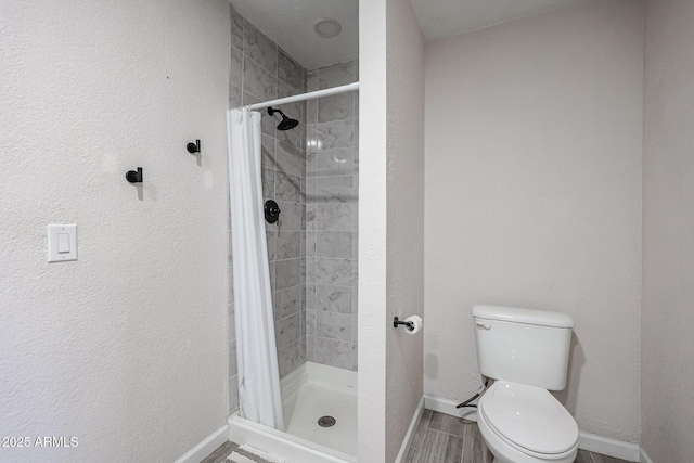 bathroom featuring toilet and curtained shower