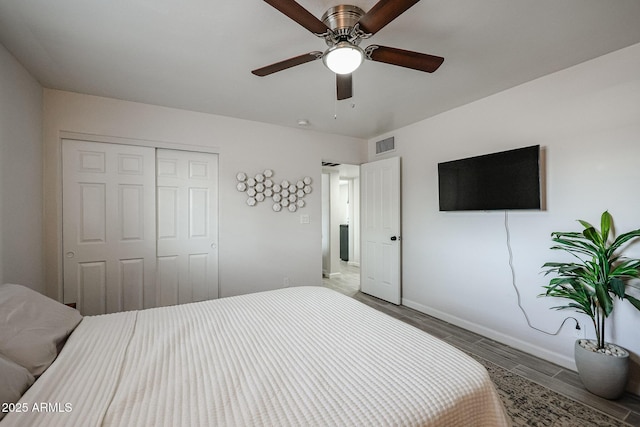 bedroom with hardwood / wood-style floors, ceiling fan, and a closet