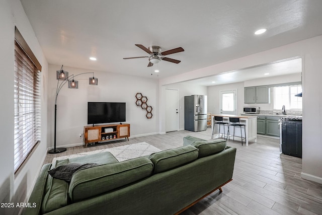 living room with ceiling fan and sink