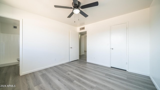 unfurnished bedroom with ensuite bath, ceiling fan, and light wood-type flooring