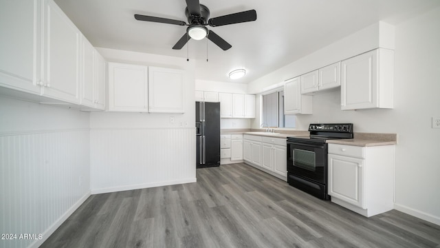 kitchen with sink, white cabinets, ceiling fan, black appliances, and light hardwood / wood-style flooring