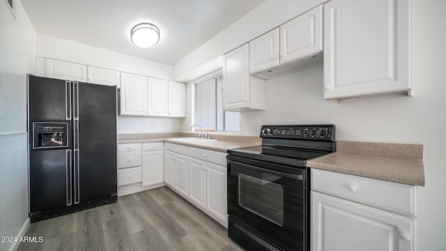 kitchen featuring white cabinetry, sink, light hardwood / wood-style flooring, and black appliances