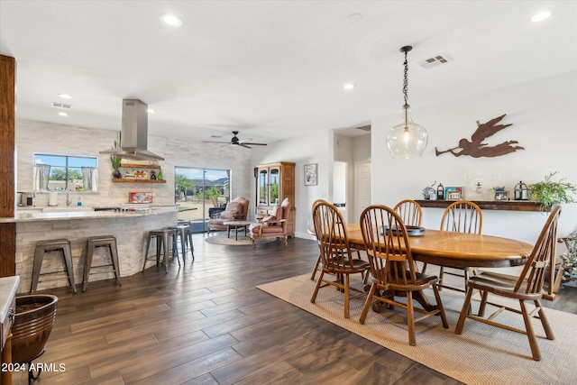 dining area with ceiling fan, dark wood-type flooring, and sink