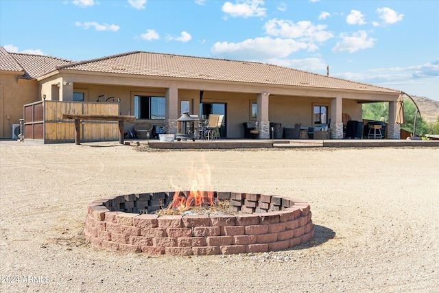 rear view of property with a fire pit