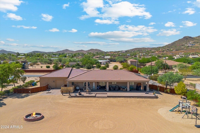 exterior space with a patio, a mountain view, a playground, and an outdoor fire pit