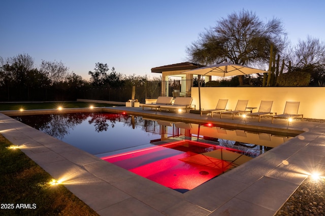 pool at dusk featuring area for grilling