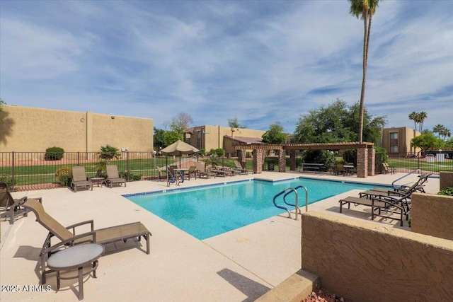 community pool featuring fence, a pergola, and a patio area
