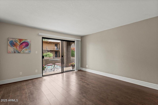 empty room featuring baseboards and wood finished floors