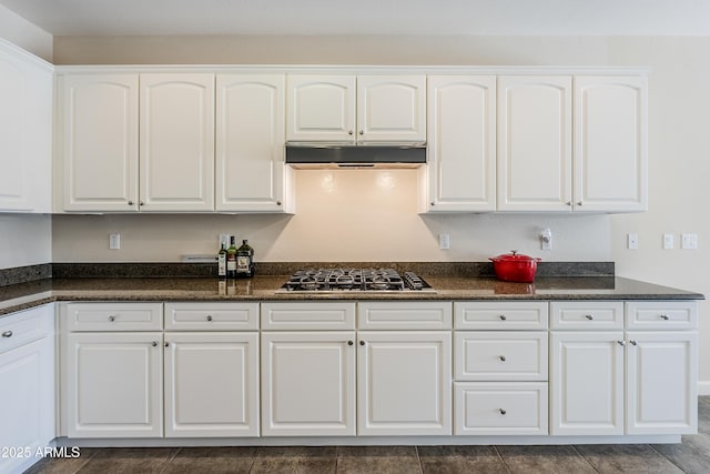 kitchen with white cabinetry, stainless steel gas cooktop, and dark stone counters