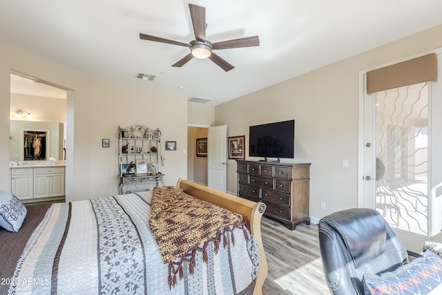 bedroom featuring ceiling fan, ensuite bathroom, and light hardwood / wood-style flooring