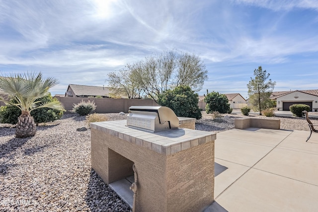 view of patio featuring an outdoor kitchen and a grill