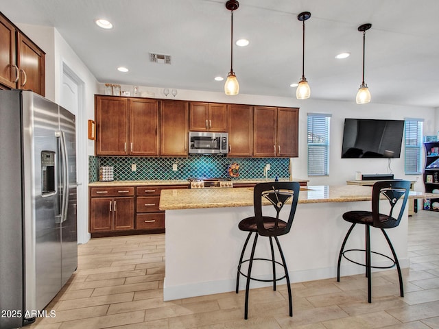 15817 S 177th Dr, Goodyear, AZ 85338 - kitchen with appliances with stainless steel finishes, decorative backsplash, light stone countertops, hanging light fixtures, and recessed lighting