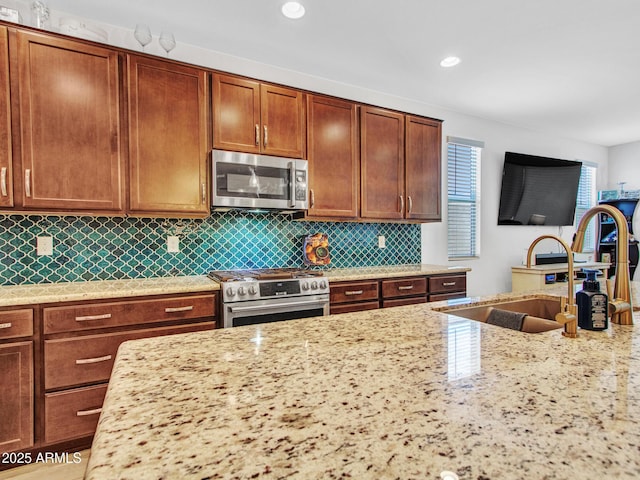 15817 S 177th Dr, Goodyear, AZ 85338 - kitchen featuring stainless steel appliances, a sink, light stone countertops, tasteful backsplash, and recessed lighting