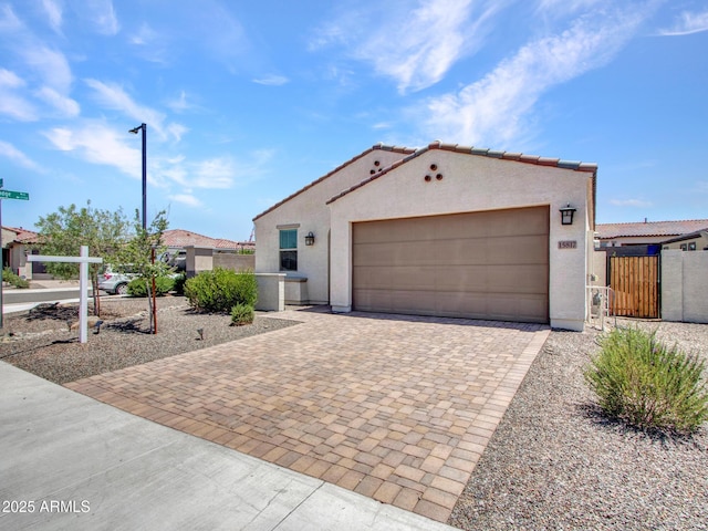 15817 S 177th Dr, Goodyear, AZ 85338 - mediterranean / spanish-style home featuring stucco siding, decorative driveway, an attached garage, a gate, and a tile roof