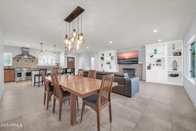 1208 E Tuckey Ln, Phoenix, AZ 85014 - dining area featuring a fireplace, recessed lighting, built in features, a chandelier, and light tile patterned floors