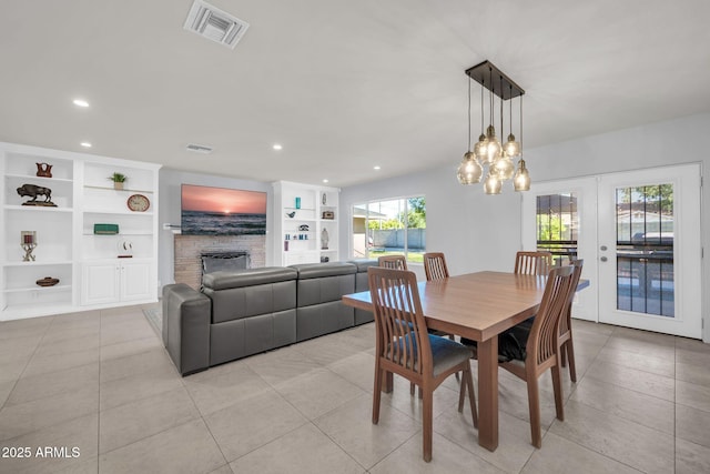 1208 E Tuckey Ln, Phoenix, AZ 85014 - dining area featuring built in shelves, a stone fireplace, recessed lighting, french doors, and light tile patterned flooring
