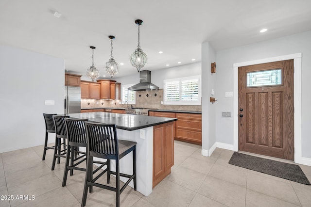 1208 E Tuckey Ln, Phoenix, AZ 85014 - kitchen featuring wall chimney exhaust hood, stainless steel refrigerator with ice dispenser, tasteful backsplash, a breakfast bar area, and recessed lighting