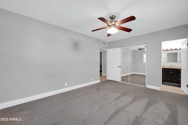 1208 E Tuckey Ln, Phoenix, AZ 85014 - unfurnished bedroom with light colored carpet, a closet, ensuite bathroom, and a ceiling fan