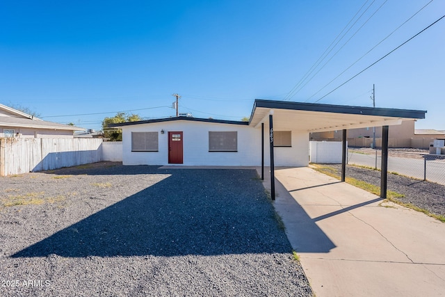 ranch-style house with a carport, driveway, and fence