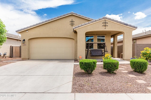 12357 W Whyman Ave, Avondale, AZ 85323 - view of front of home featuring concrete driveway, an attached garage, stucco siding, fence, and a tiled roof