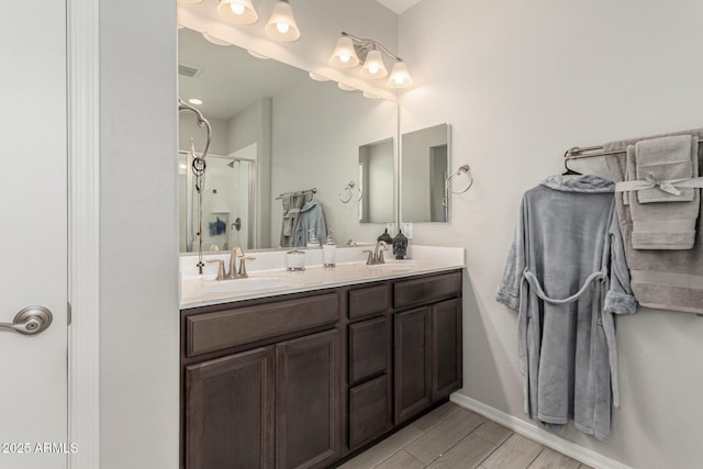 12357 W Whyman Ave, Avondale, AZ 85323 - bathroom featuring a shower stall, double vanity, wood finished floors, and baseboards