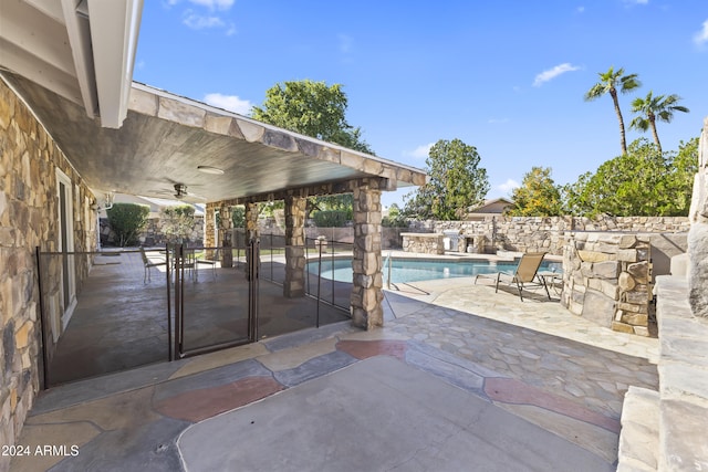 view of patio with a fenced in pool and ceiling fan