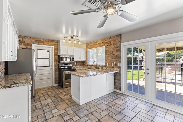 kitchen featuring appliances with stainless steel finishes, white cabinets, sink, and plenty of natural light