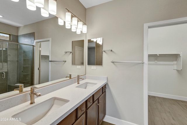 bathroom with a shower with door, hardwood / wood-style flooring, and vanity