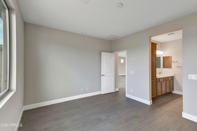 interior space featuring sink, ensuite bath, and light hardwood / wood-style floors