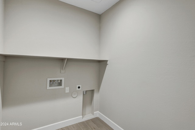 laundry area with washer hookup, hookup for an electric dryer, gas dryer hookup, and light wood-type flooring