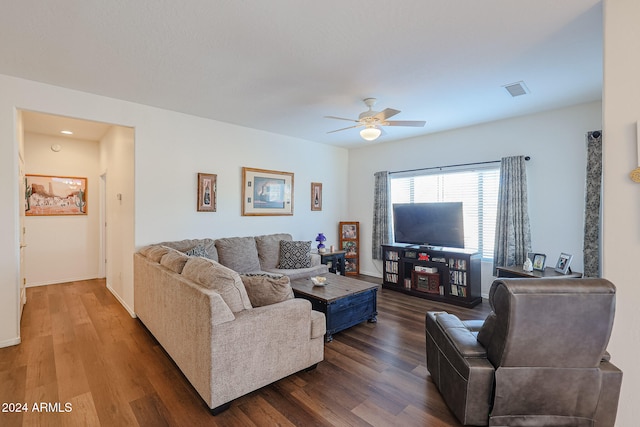 living room featuring ceiling fan and dark wood-type flooring