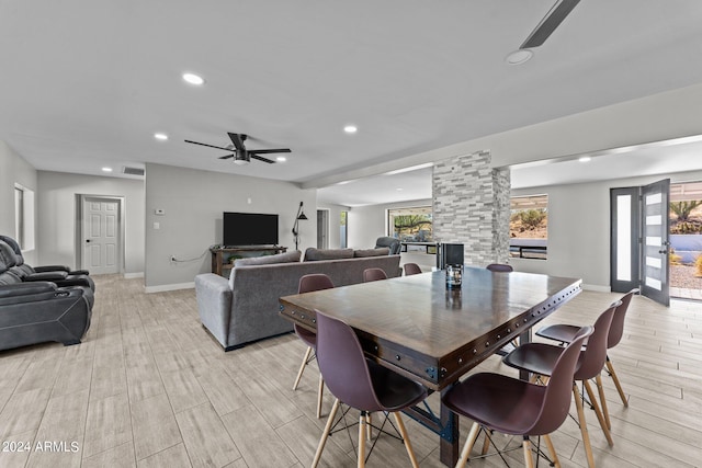 dining space with ceiling fan, light wood-type flooring, and ornate columns