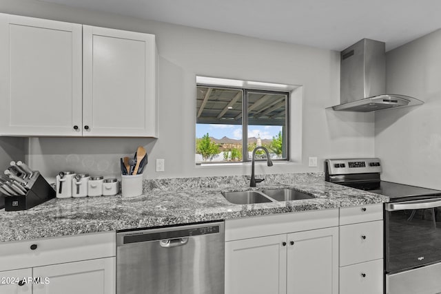 kitchen with white cabinets, wall chimney range hood, sink, and appliances with stainless steel finishes