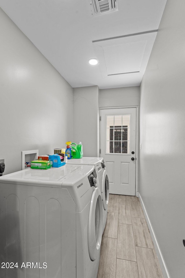 laundry area with washer and dryer and light hardwood / wood-style flooring