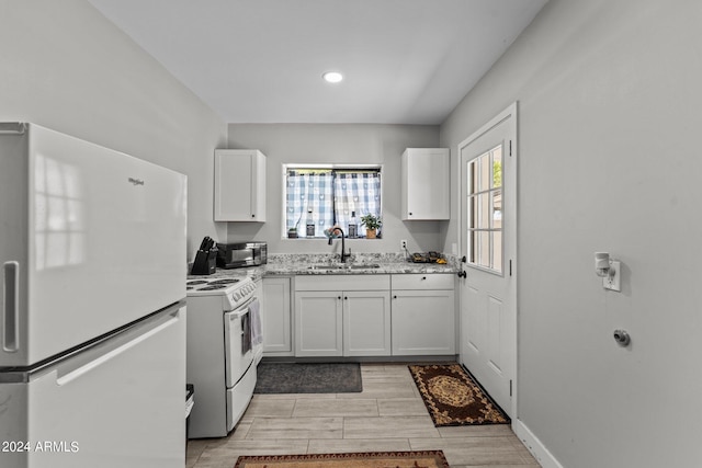 kitchen featuring white cabinets, light stone counters, white appliances, and sink