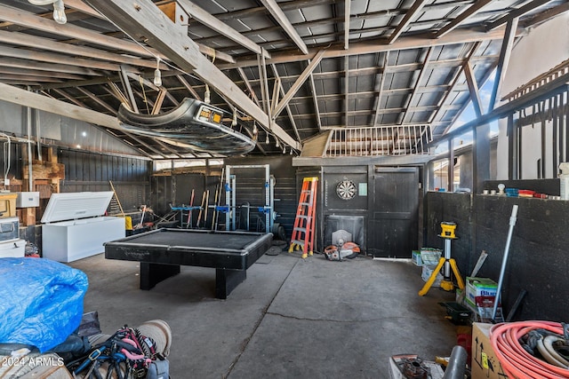 recreation room featuring concrete flooring and vaulted ceiling