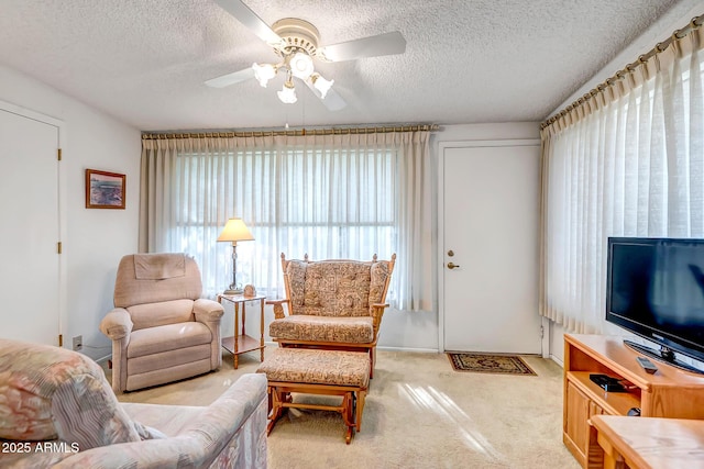 carpeted living room featuring a textured ceiling and ceiling fan