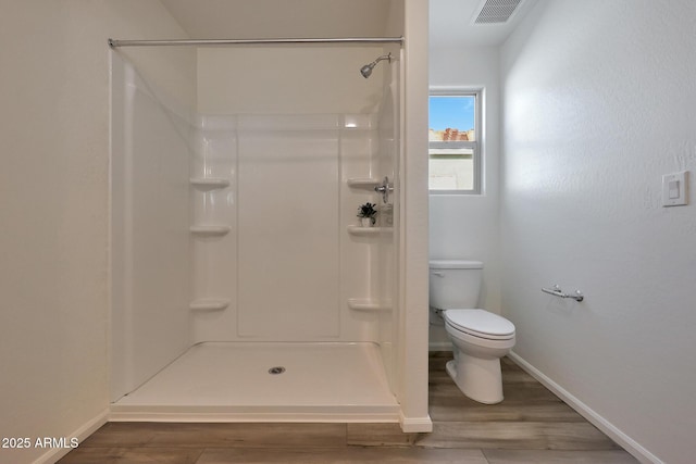 bathroom with toilet, wood-type flooring, and walk in shower