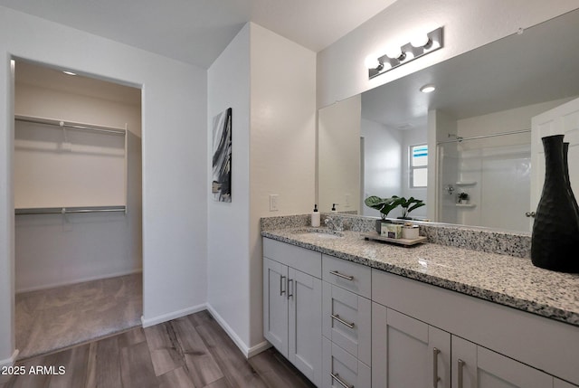 bathroom with a shower, vanity, and wood-type flooring