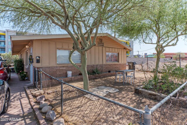 2017 E Lemon St, Tempe, AZ 85281 - view of side of home featuring board and batten siding, a fenced backyard, and a patio area