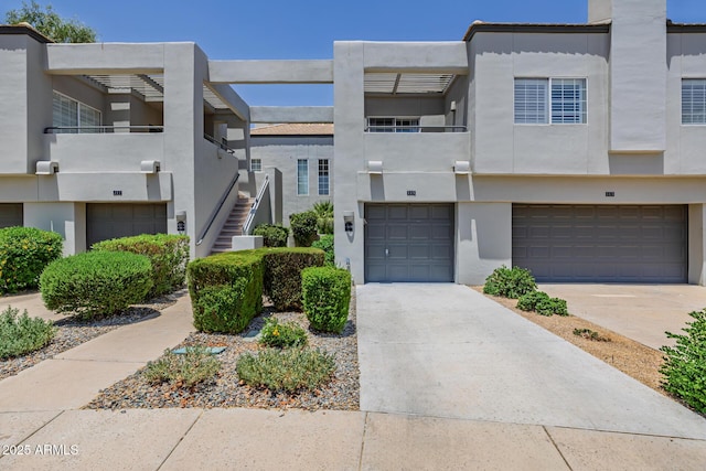 7710 E Gainey Ranch Rd E Unit 115, Scottsdale, AZ 85258 - view of front of property featuring stucco siding, a garage, driveway, and stairs
