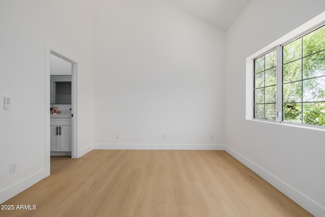 7710 E Gainey Ranch Rd E Unit 115, Scottsdale, AZ 85258 - unfurnished room featuring plenty of natural light, light wood-style floors, and vaulted ceiling