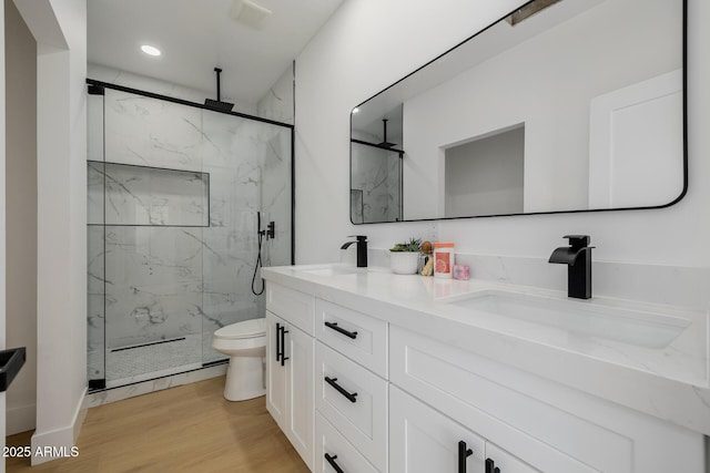 7710 E Gainey Ranch Rd E Unit 115, Scottsdale, AZ 85258 - bathroom featuring double vanity, a marble finish shower, wood finished floors, and recessed lighting